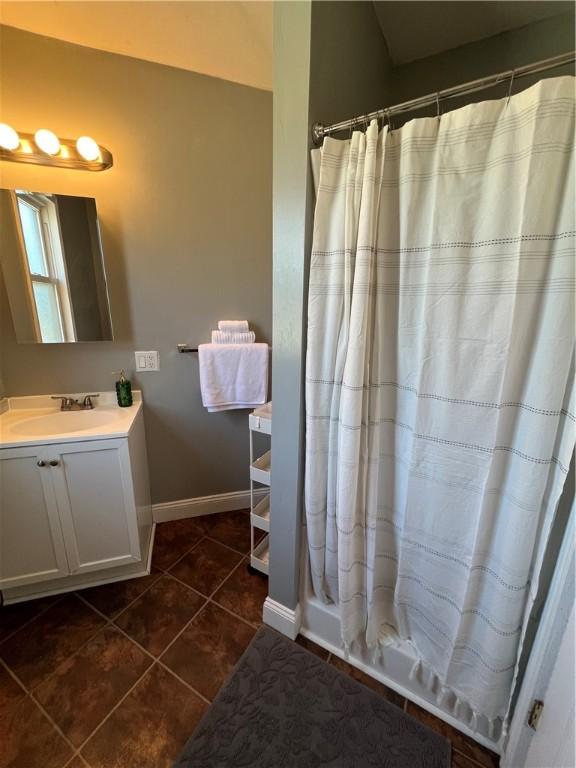 bathroom featuring a shower with shower curtain, vanity, and tile patterned floors