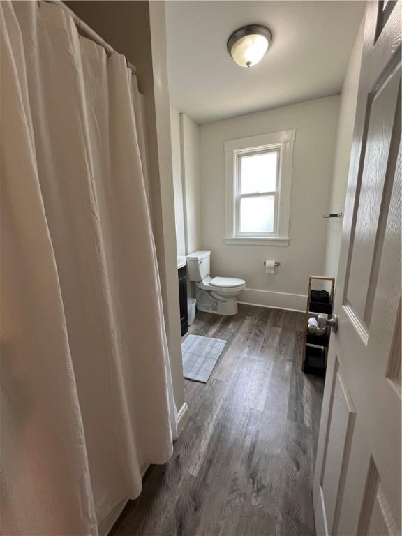 bathroom with toilet, vanity, and hardwood / wood-style flooring