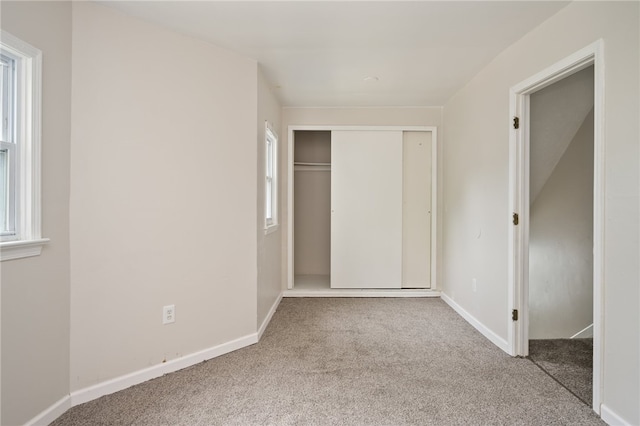 unfurnished bedroom with light carpet and a closet