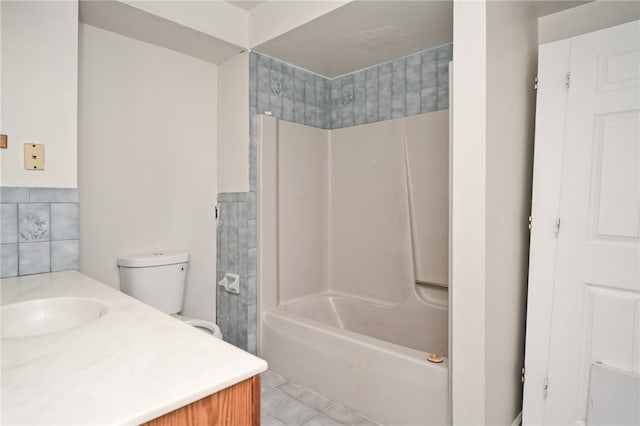 full bathroom featuring vanity, tile walls, washtub / shower combination, tile patterned flooring, and toilet