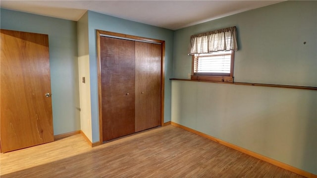 unfurnished bedroom featuring light wood-type flooring and a closet