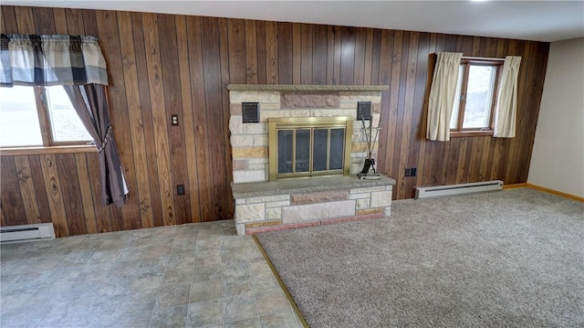 unfurnished living room featuring a fireplace, wooden walls, plenty of natural light, and a baseboard radiator