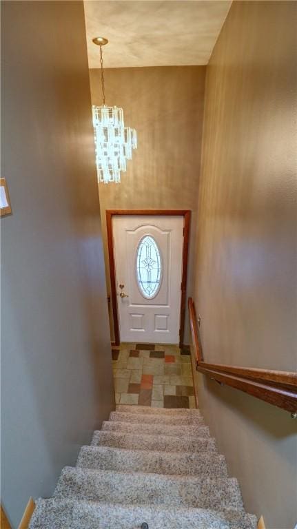 stairs with an inviting chandelier