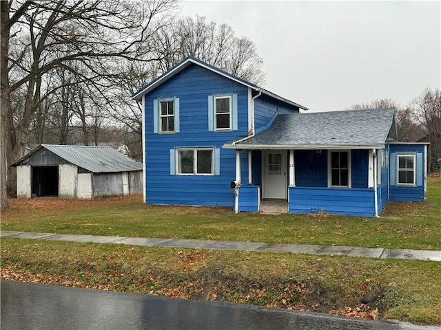 view of front of house featuring a porch, a front lawn, and an outdoor structure