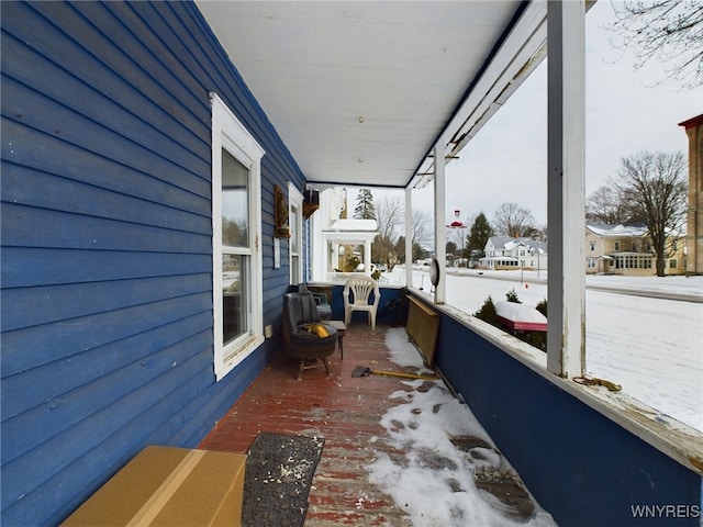 snow covered deck with a porch