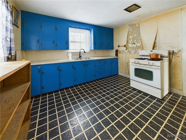 kitchen with blue cabinets, sink, white gas range oven, and backsplash