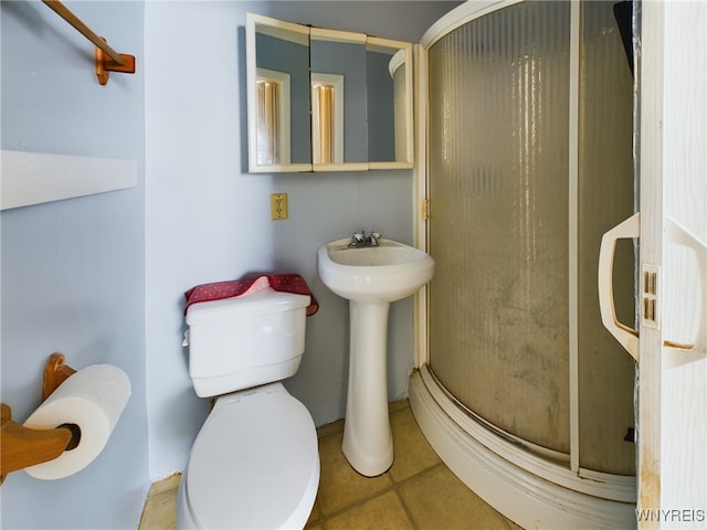 bathroom with sink, tile patterned floors, toilet, and a shower with door