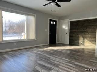 unfurnished living room with ceiling fan and dark hardwood / wood-style floors