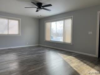 empty room with dark hardwood / wood-style floors and ceiling fan