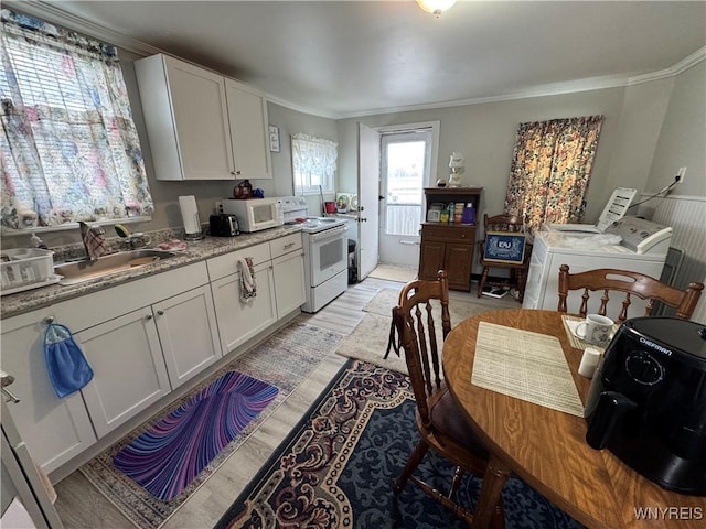 kitchen featuring white cabinetry, separate washer and dryer, crown molding, white appliances, and light wood-type flooring