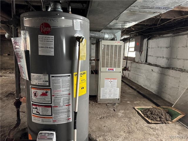 utility room with electric panel, heating unit, and gas water heater