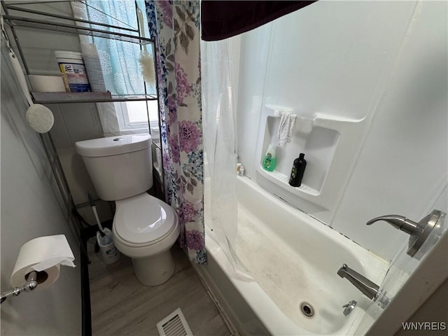 bathroom featuring toilet, wood-type flooring, and shower / tub combo with curtain