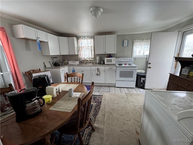 kitchen featuring white cabinets, plenty of natural light, light wood-type flooring, and white appliances