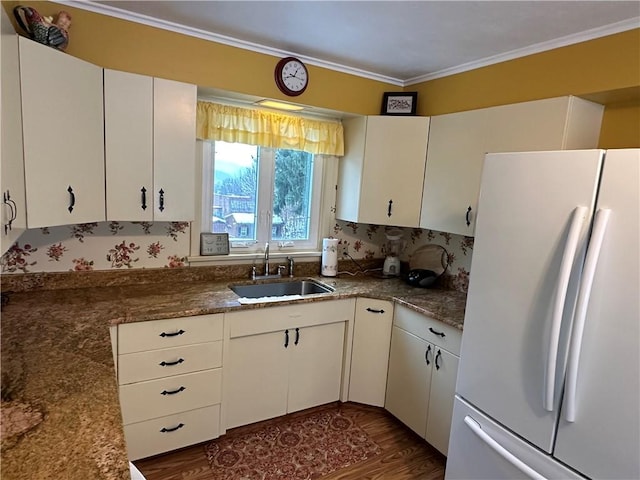 kitchen featuring crown molding, sink, white refrigerator, dark hardwood / wood-style floors, and white cabinetry