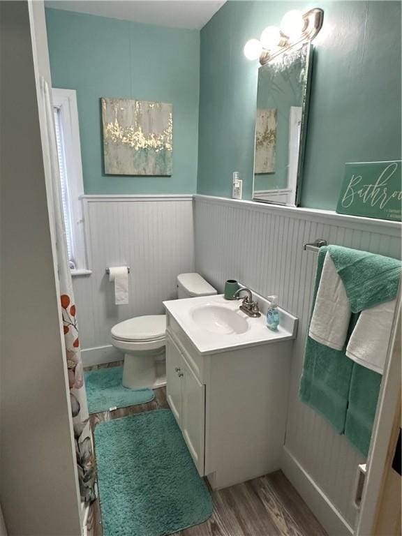 bathroom with hardwood / wood-style floors, vanity, and toilet