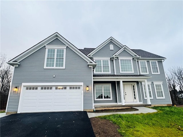 front facade featuring a garage and a front lawn