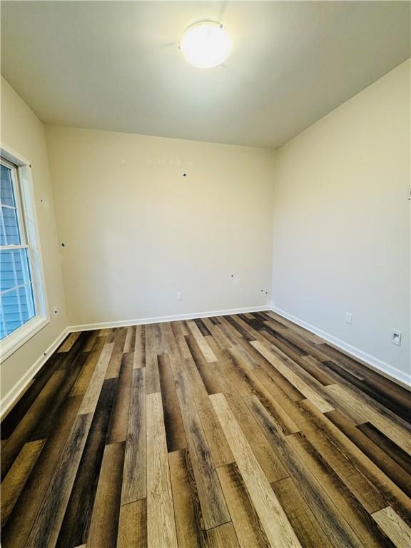 empty room with dark wood-type flooring