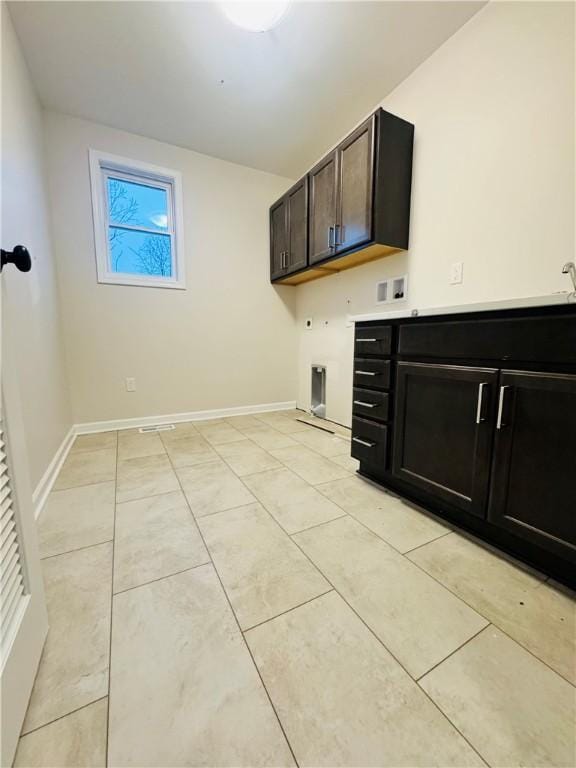 washroom featuring cabinets, washer hookup, light tile patterned floors, and electric dryer hookup