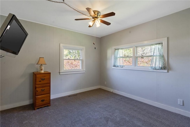 unfurnished bedroom featuring carpet flooring, multiple windows, and ceiling fan