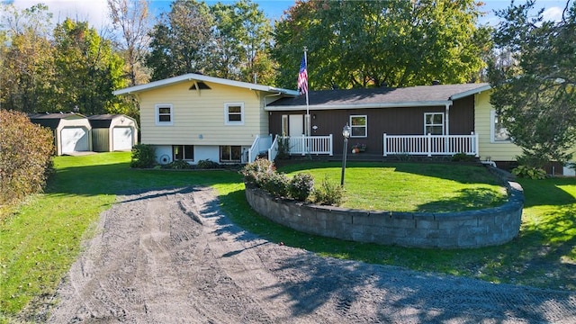 split level home with a porch, an outbuilding, a front yard, and a garage