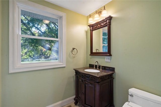 bathroom featuring vanity, toilet, and a wealth of natural light