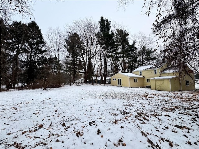 snowy yard featuring an outbuilding