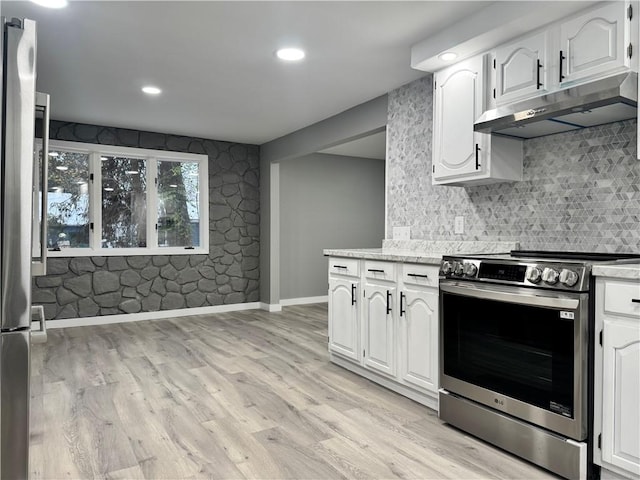 kitchen with white cabinets, appliances with stainless steel finishes, light wood-type flooring, and backsplash