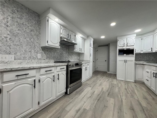 kitchen featuring white cabinets, backsplash, stainless steel appliances, and light hardwood / wood-style flooring