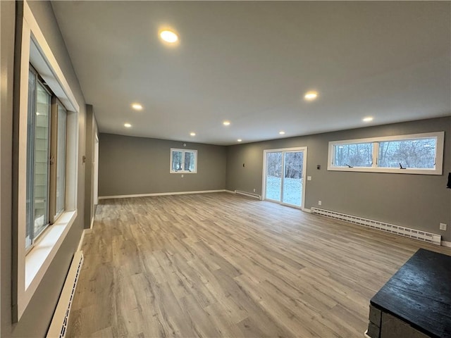 spare room with light wood-type flooring and a baseboard radiator