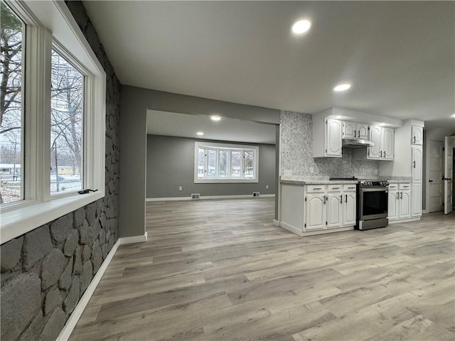 kitchen featuring stainless steel electric stove, white cabinetry, and light hardwood / wood-style flooring