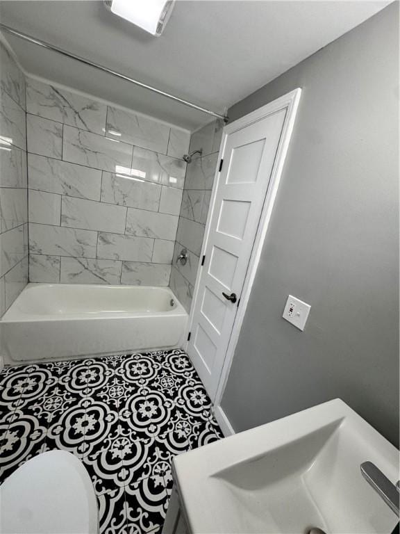 full bathroom featuring tile patterned floors, sink, tiled shower / bath combo, and toilet