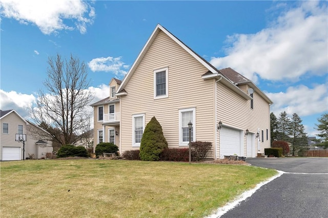 view of side of home featuring a lawn and a garage