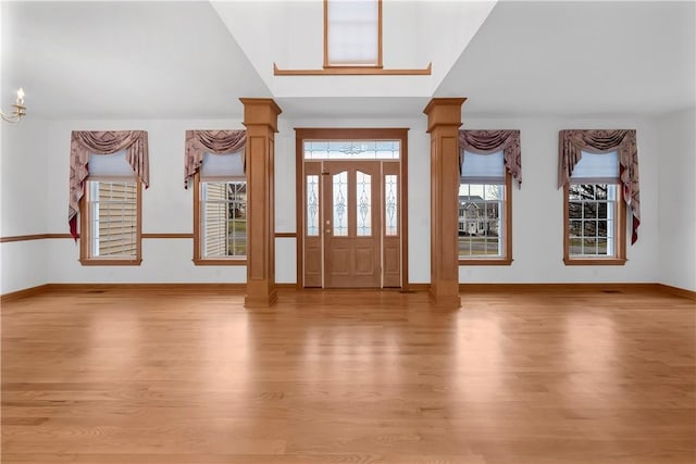 foyer featuring decorative columns and light hardwood / wood-style floors