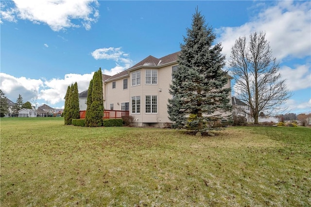 back of property featuring a deck and a yard