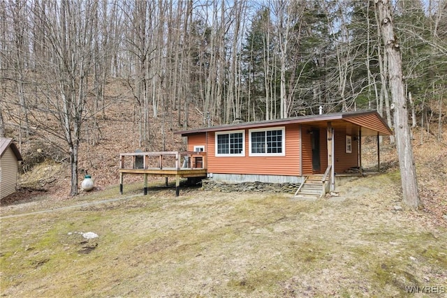 view of front of home featuring a front lawn and a wooden deck