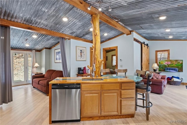 kitchen with lofted ceiling with beams, plenty of natural light, dishwasher, a barn door, and open floor plan