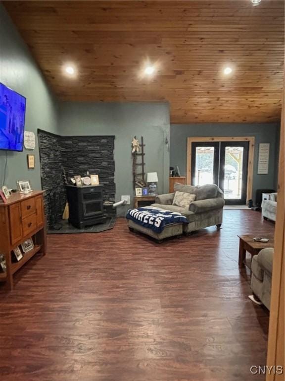 living room featuring lofted ceiling, dark hardwood / wood-style floors, a wood stove, and wooden ceiling