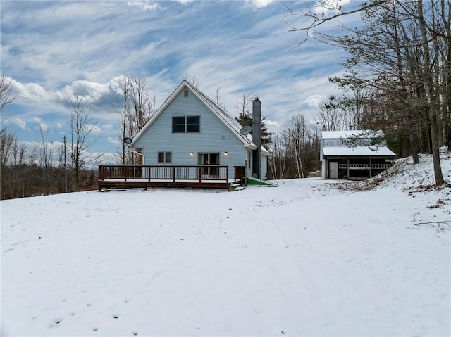 snow covered back of property with a deck