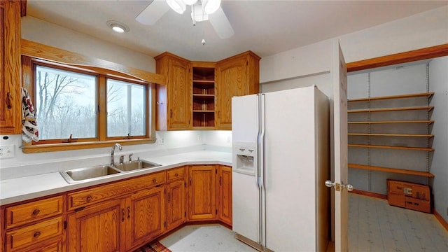 kitchen with ceiling fan, white fridge with ice dispenser, and sink