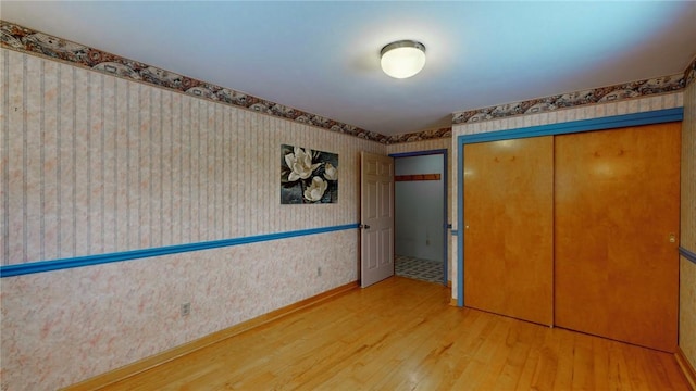 unfurnished bedroom with wood-type flooring and a closet