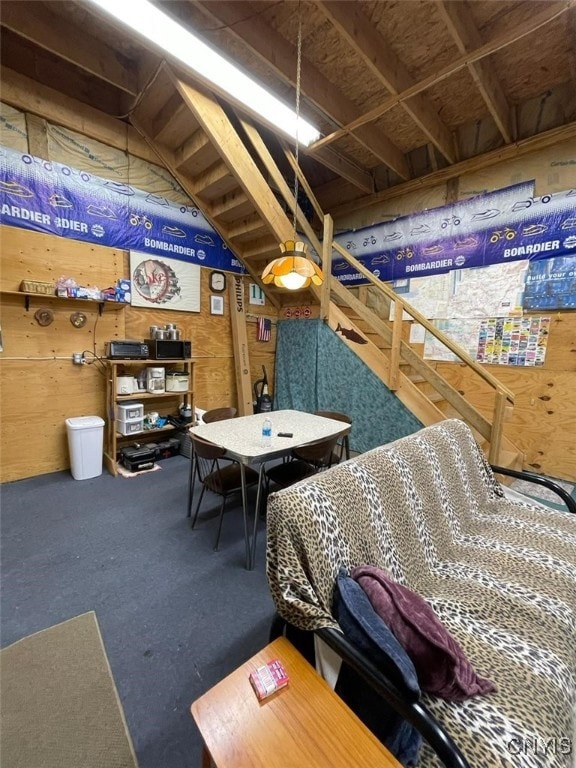 recreation room with wooden walls and vaulted ceiling