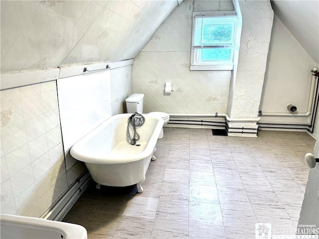 bathroom featuring a tub to relax in, tile walls, and vaulted ceiling