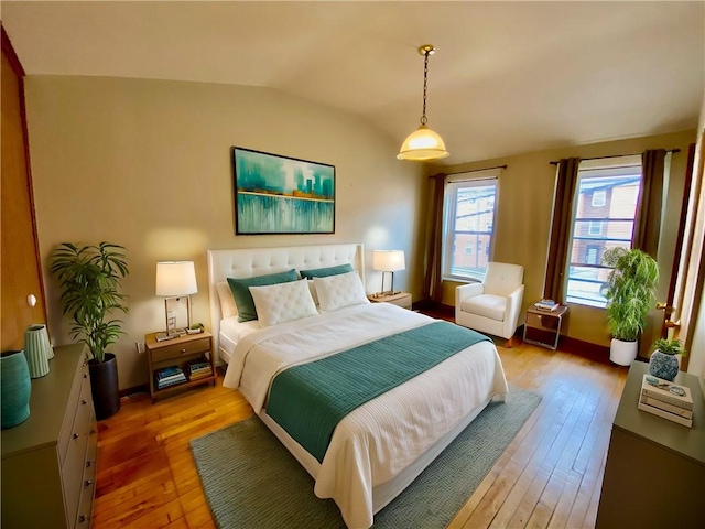 bedroom featuring hardwood / wood-style flooring and vaulted ceiling