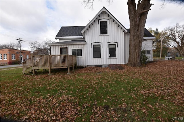 back of property featuring a lawn and a deck