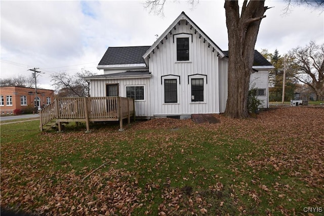 228 Main St, Theresa, NY 13691 - rear view of house featuring board and batten siding, a wooden deck, roof with shingles, and a yard