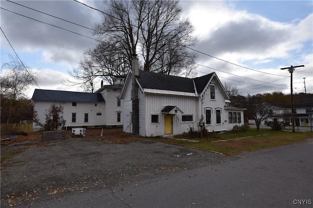 228 Main St, Theresa, NY 13691 - view of front of house featuring a chimney, driveway, and board and batten siding