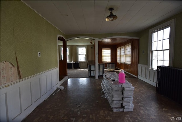 228 Main St, Theresa, NY 13691 - foyer with arched walkways, healthy amount of natural light, wainscoting, radiator heating unit, and a decorative wall