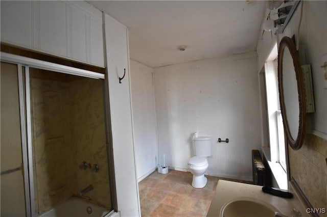 228 Main St, Theresa, NY 13691 - bathroom featuring vanity, enclosed tub / shower combo, stone finish flooring, and radiator heating unit