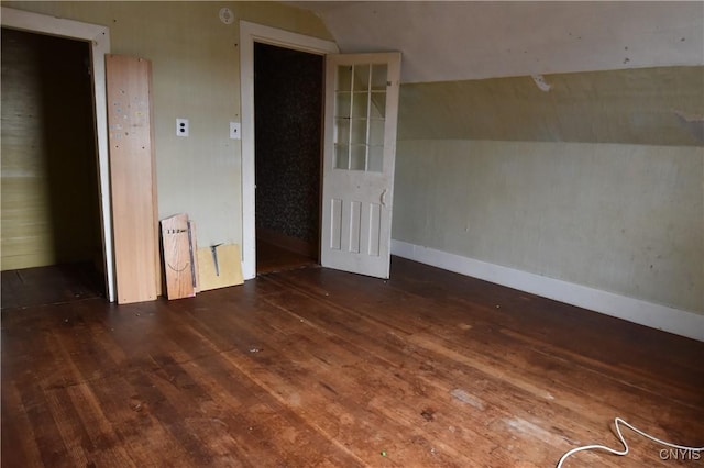 empty room with dark hardwood / wood-style floors and vaulted ceiling