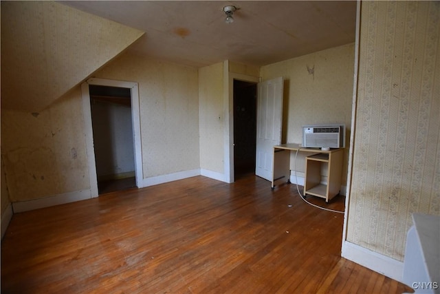 interior space featuring a wall mounted air conditioner and hardwood / wood-style flooring